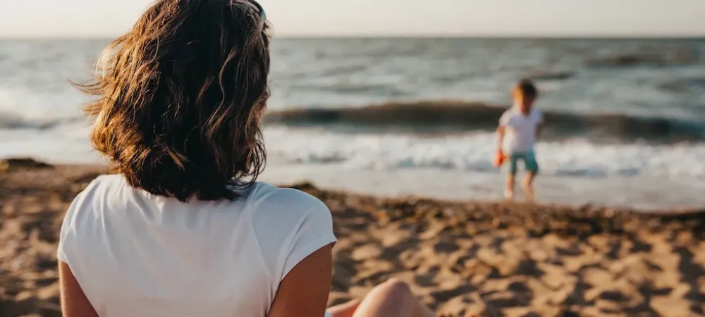 Mother watching her children enjoying the beach